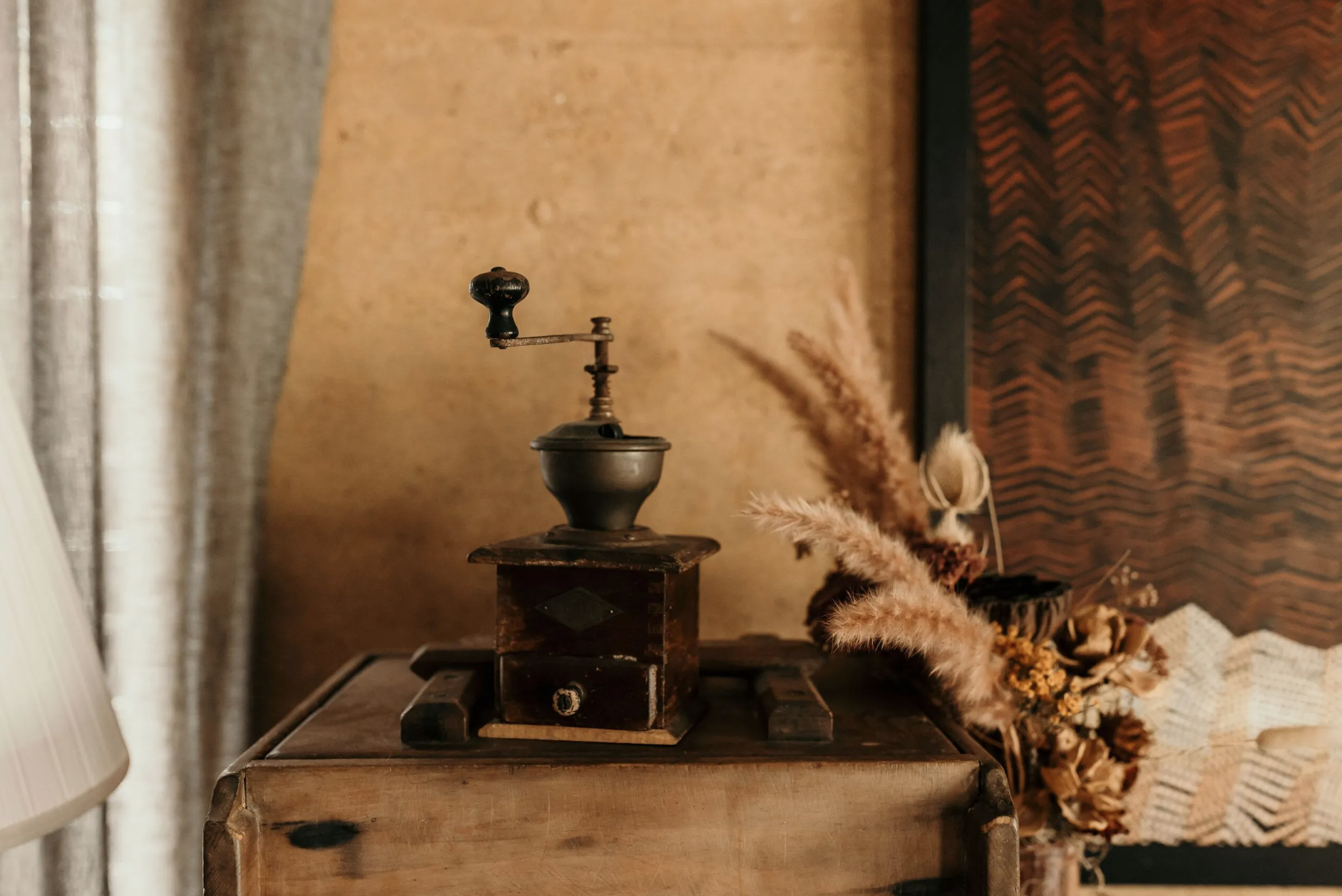 Vintage coffee grinder against rammed-earth wall