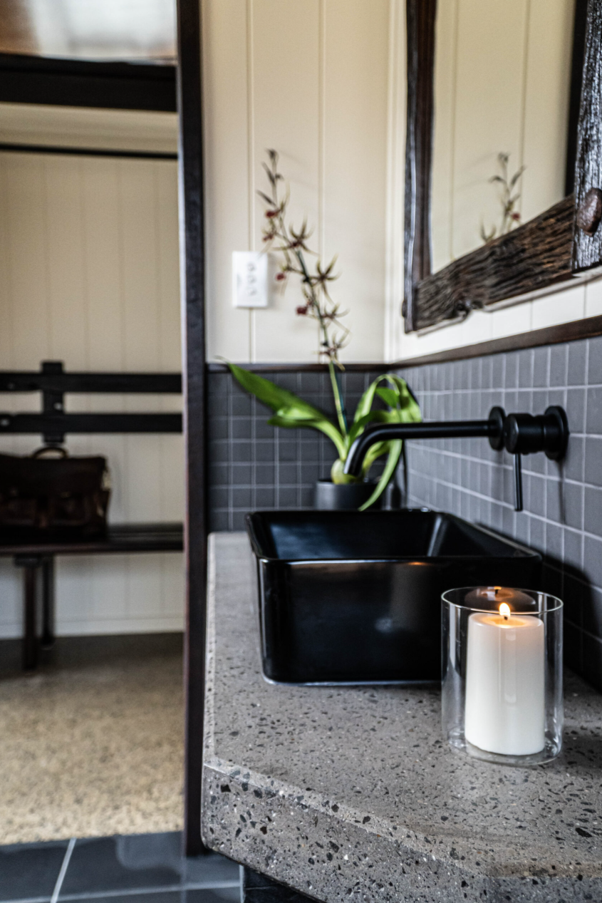 Bathroom vanity with black basin and candle