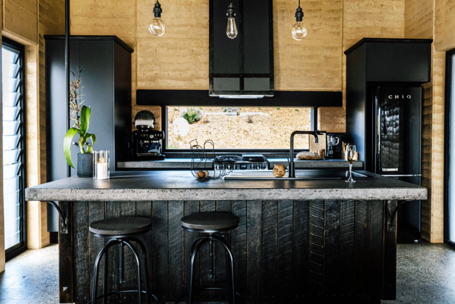 Galley kitchen with concrete bench and rammed-earth walls