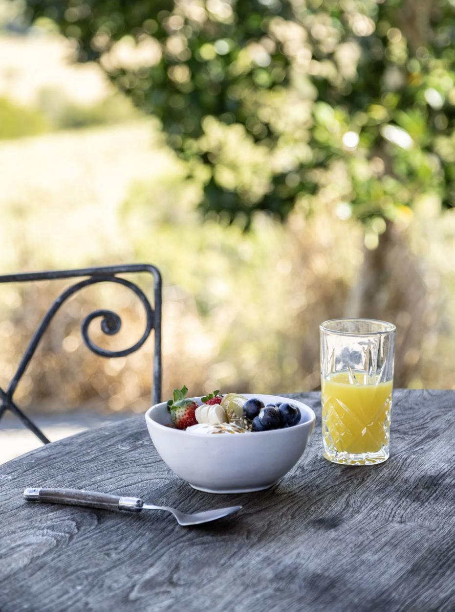 Yoghurt and berries with fresh juice on the outdoor table