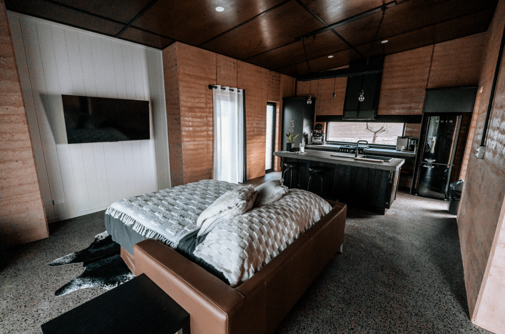 Open-plan villa interior with bed and kitchen