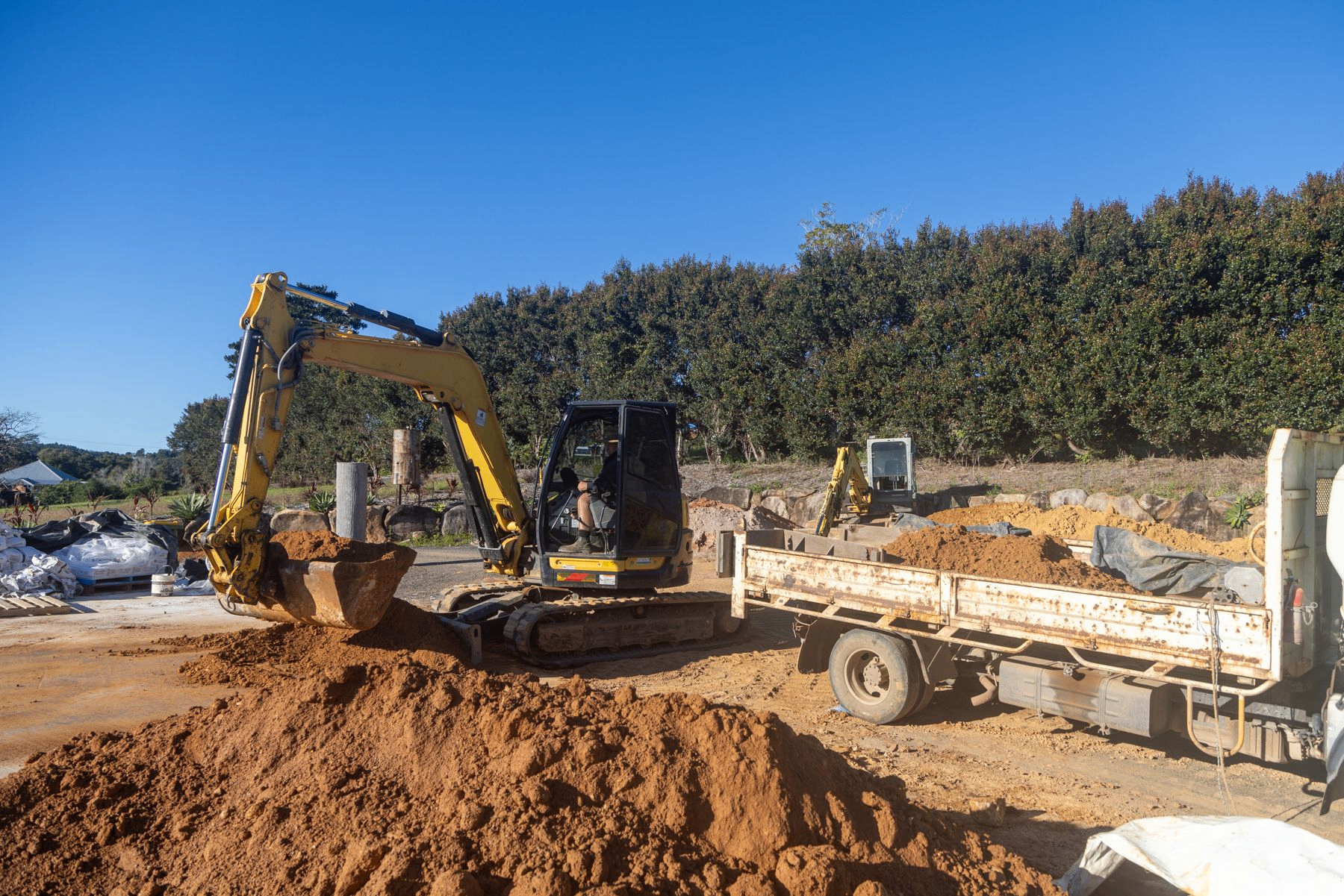 Small excavator loading earth from the farm