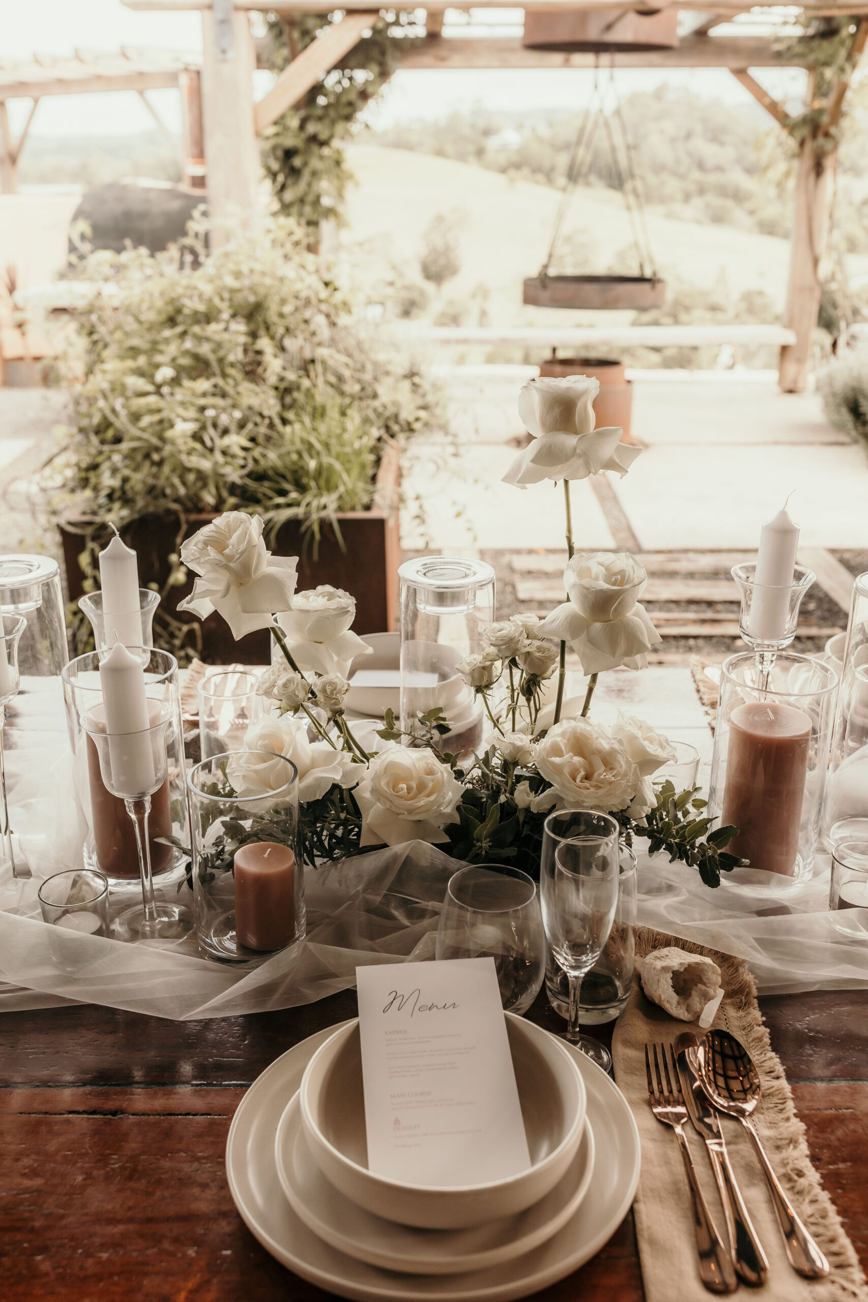A long timber dining table set outdoors at golden hour